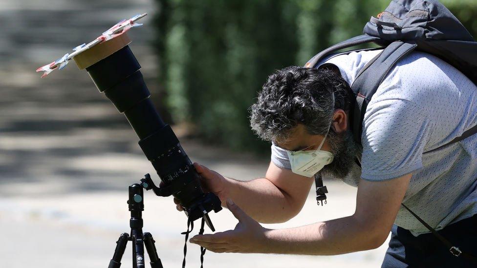 A man observes partial solar eclipse in Brussels, Belgium.