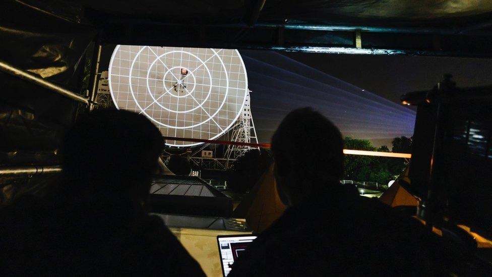 A projection team test the light show on the Lovell radio telescope