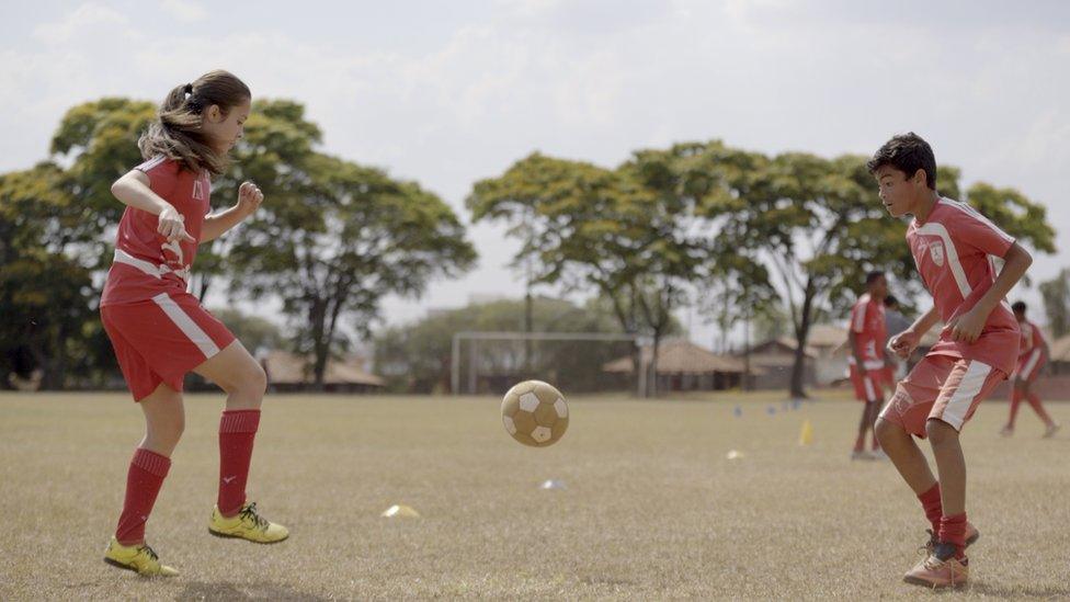 Laura Pigatin playing football with her team members