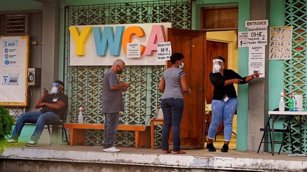 People queue to enter a polling station to cast their votes during the election for a new prime minister, in Belize City, Belize November 11, 2020.