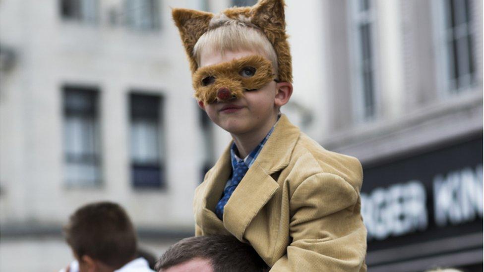 A fan watches the action dressed as a fox