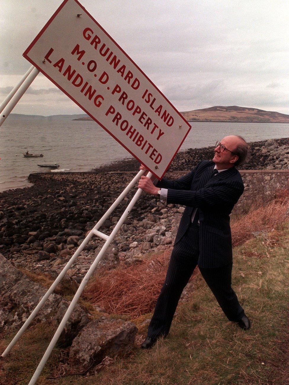 Junior Defence Minister Michael Neubert removes the last warning sign for Gruinard island