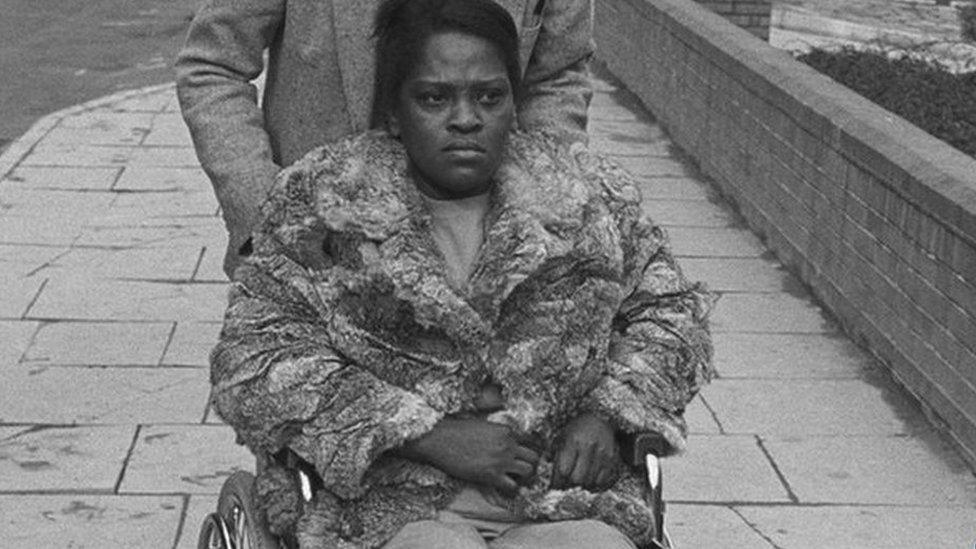 Cherry Groce being pushed in a wheelchair