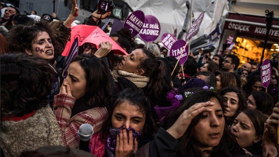 Women's rights activists react during clashes with Turkish riot police as they try to march to Taksim Square to protest against gender violence in Istanbul, on November 25, 2018