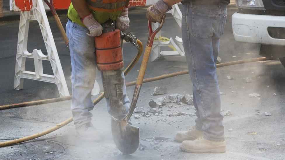 Workers digging up a road