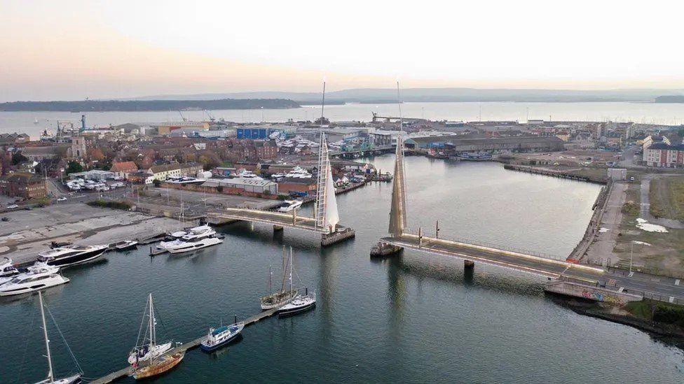 The Twin Sails Bridge in Poole, in the open position, with Poole Harbour in the background