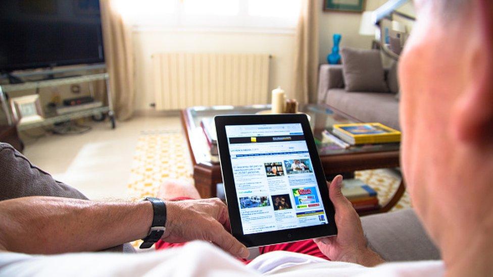 A man reading the news on an iPad