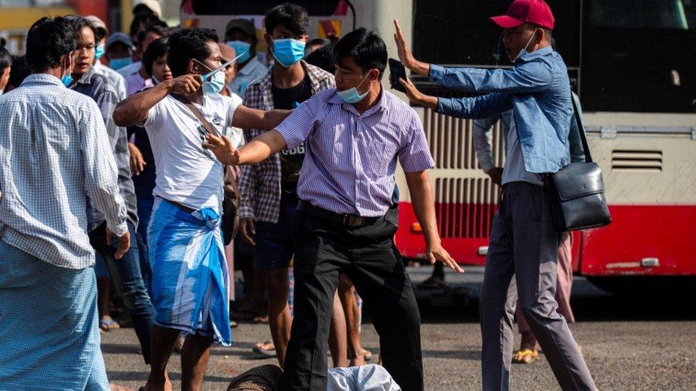 A military supporter points a sharp object as he confronts anti-coup protesters in Myanmar