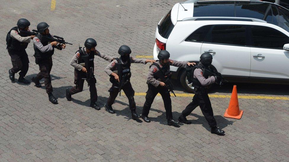 Indonesian police commandos arrive near the damaged Starbucks coffee shop