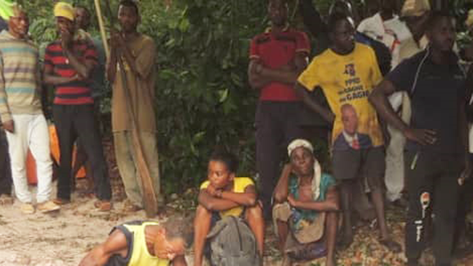 Sombre people looking on at the rescue effort on Lake Mai-Ndombe in DR Congo