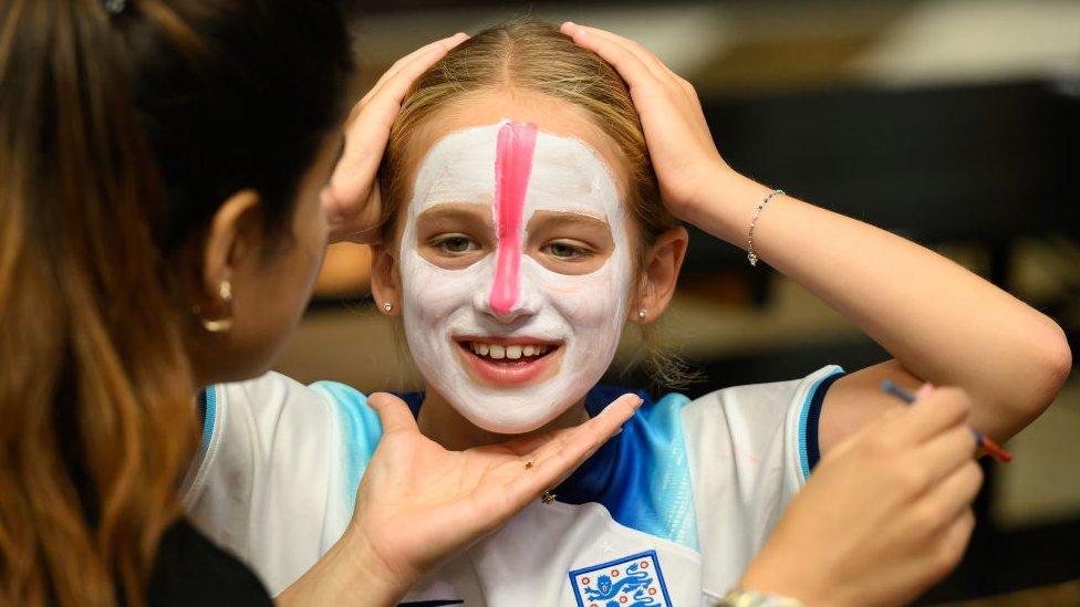 young fan getting face paint