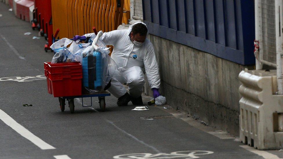 Forensics officers collect evidence at the scene