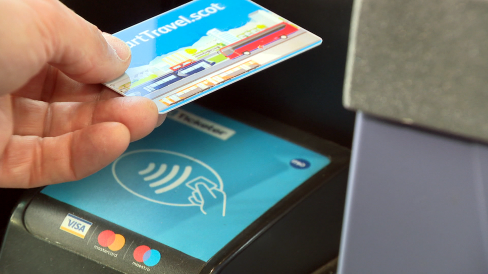 A close up of someone using a smartcard on a bus