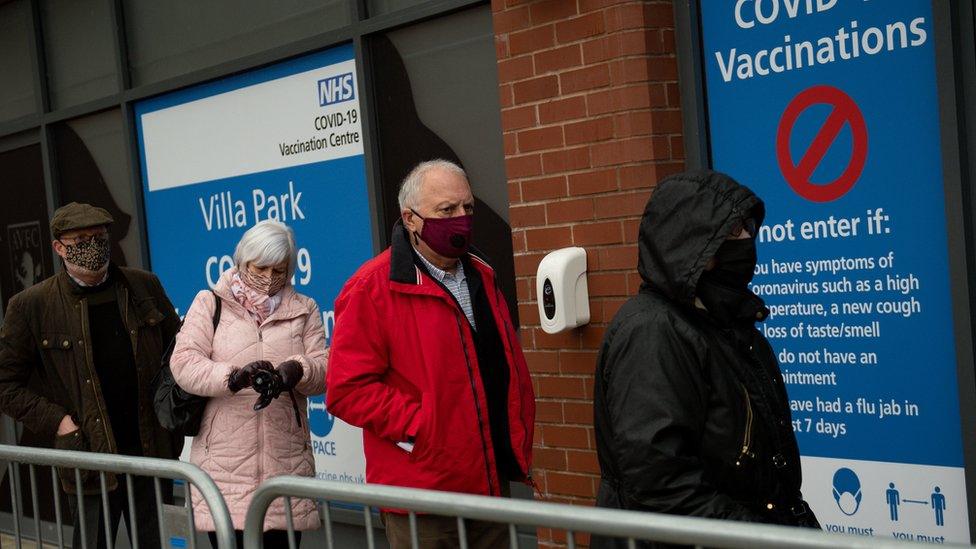 Members of the public arrive to receive a dose of a Covid-19 vaccine, at a temporary coronavirus vaccination hub set up at Villa Park football stadium