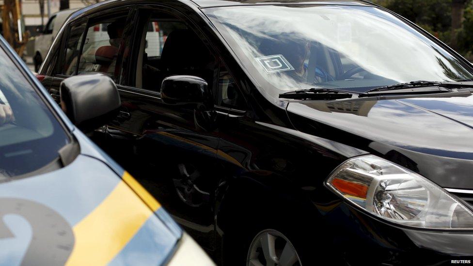 The Uber logo is seen on a vehicle next to a taxi near Union Square in San Francisco