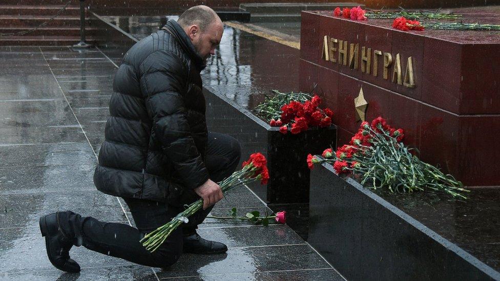 A man lays flowers at a memorial to the hero city of Leningrad in central Moscow in memory of victims of the blast in the St Petersburg metro, 3 April 2017