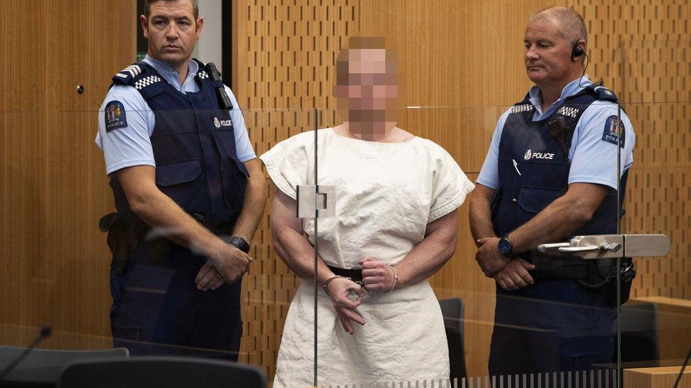 Brenton Tarrant (Pixelated) makes a sign to the camera during his appearance, on a charge of murder for Christchurch mosque massacre in the District Court, Christchurch, New Zealand, 16 March 2019, reissued 05 April 2019