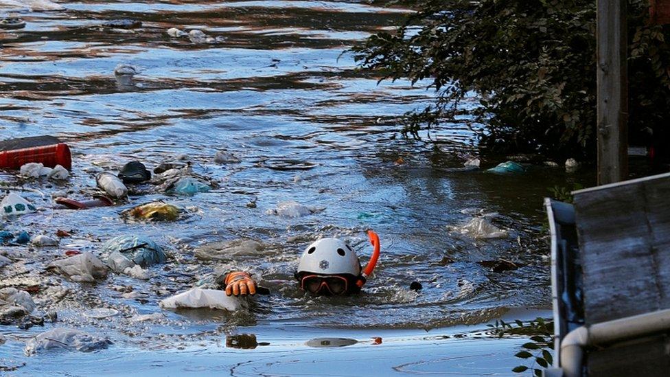 A rescue worker swims as he checks around a flooded residential area due to Typhoon Hagibis, in Kawasaki, Japan, October 13, 2019