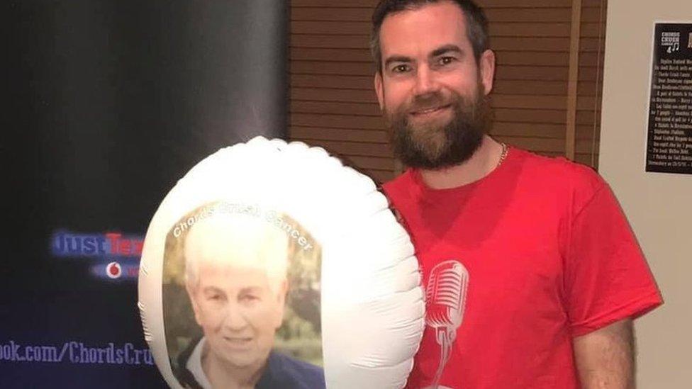 Mark Fielden holding a balloon with a picture of his late mum