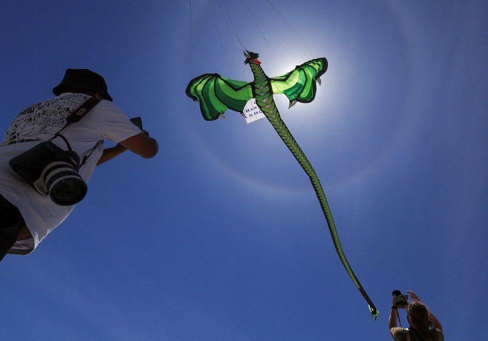 Journalists photograph kites during a practice run at Dolphin Beach ahead of this weekend's 30th Cape Town International Kite Festival, an awareness campaign for World Mental Health Day where kite enthusiasts gather to fly colourful kites to raise funds for mental health support, in Cape Town, South Africa, October 22.