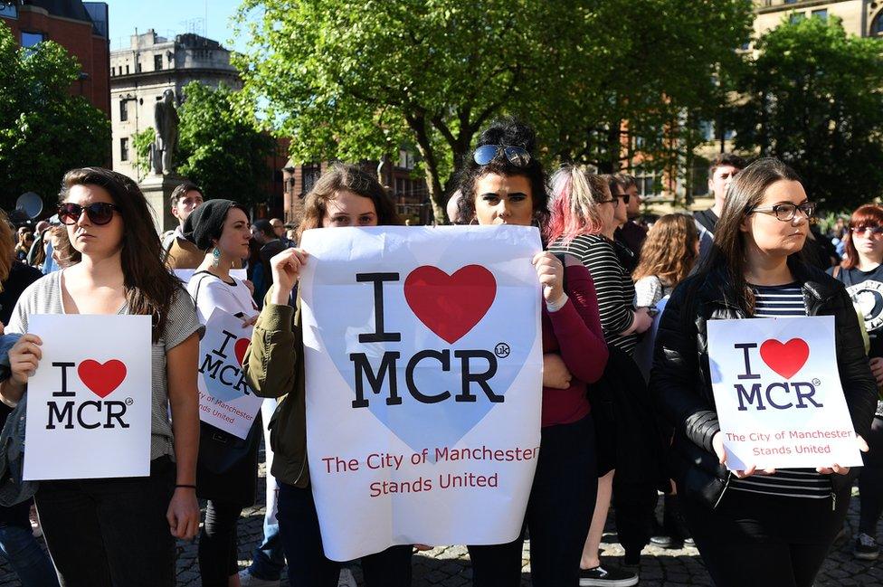 People attend a vigil for the people who lost their lives during the Manchester terror attack.