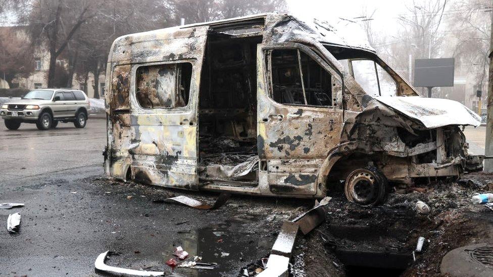 A burnt minibus pictured in a street in Kazakhstan's main city, Almaty