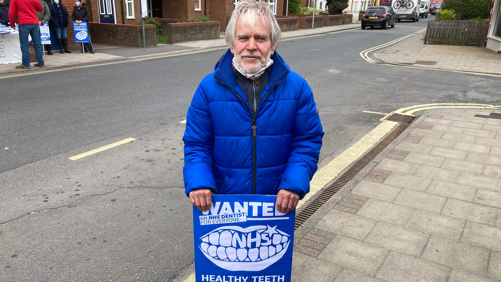 Clive Chrichton, 67, from Lewiston, holding a placard