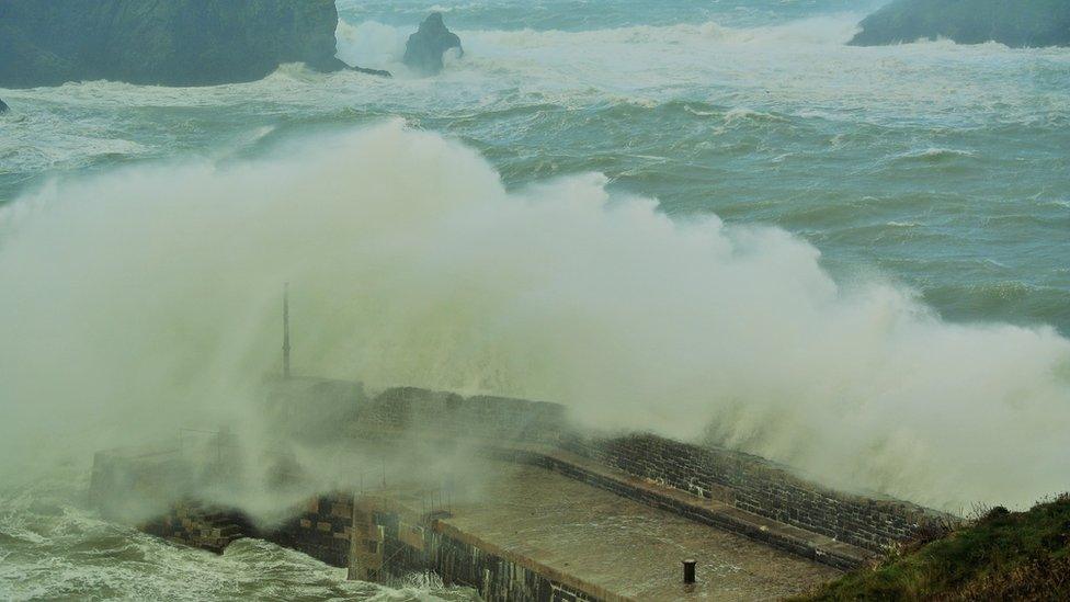 Waves crashing over Mullion harbour in Cornwall