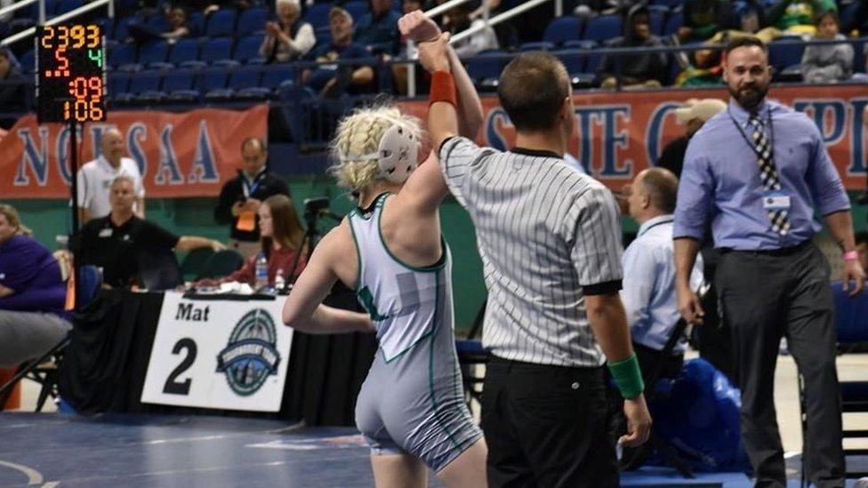 Heaven's arm held aloft by the referee. Her coach can be seen nearby.