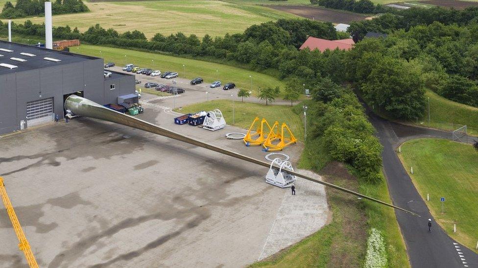 Aerial shot of prototype turbine blade emerging from factory