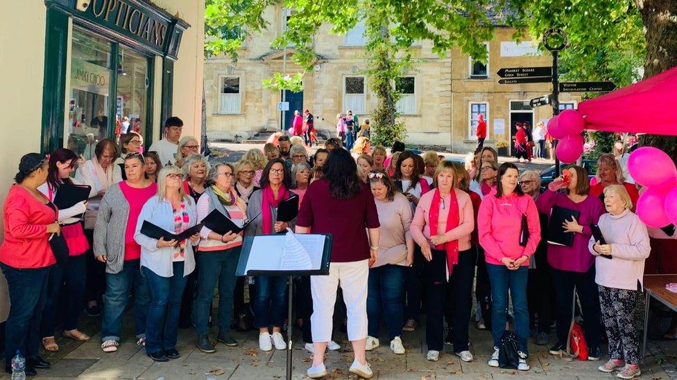 A choir donned in pink clothing stood on Witney high street.