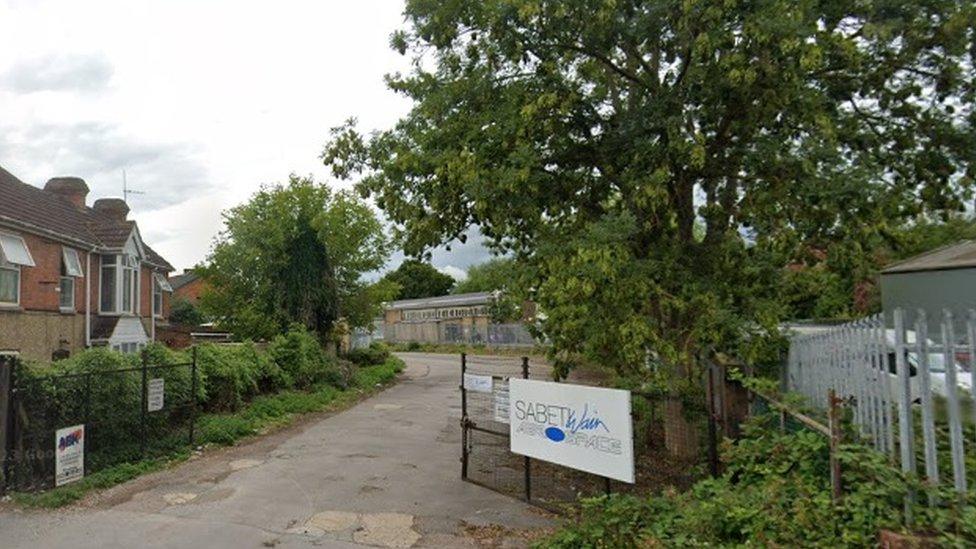 Entrance to factory site with gates and Sabeti Wain sign