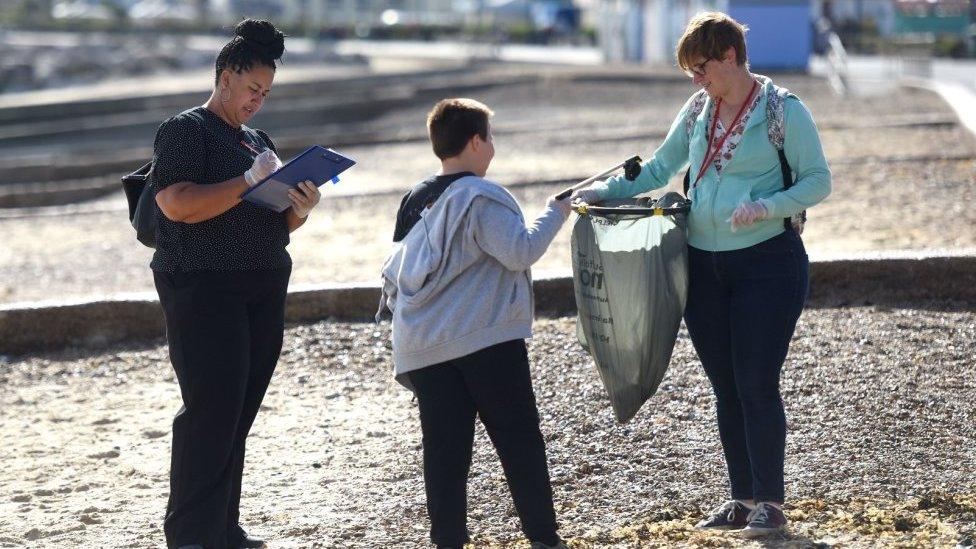 People picking up litter on a beach