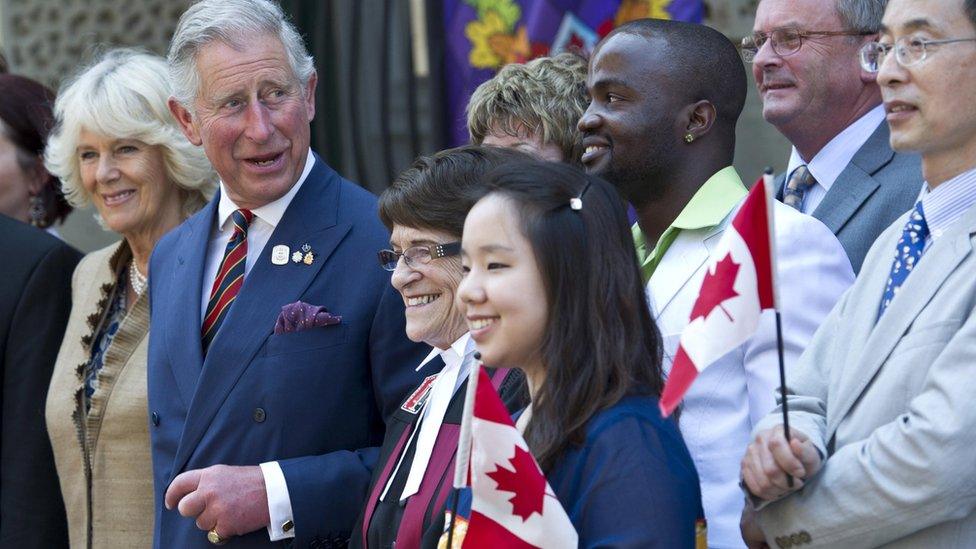 Prince Charles and his wife Camilla pose for a photograph with newly sworn in Canadian citizens following a swearing-in ceremony in Saint John, New Brunswick