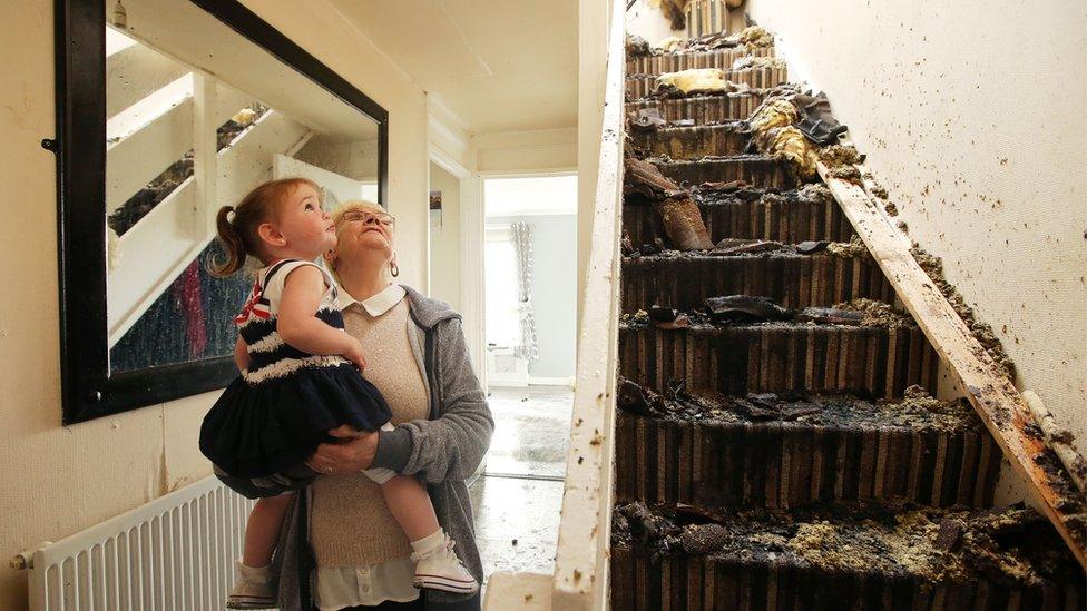 Lily Turtle and her grand-daughter Skyla Hogg look at the damage done to her house