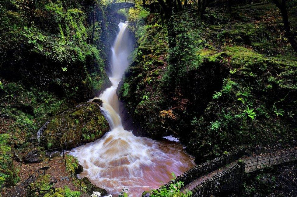 A long thing waterfall between rocks