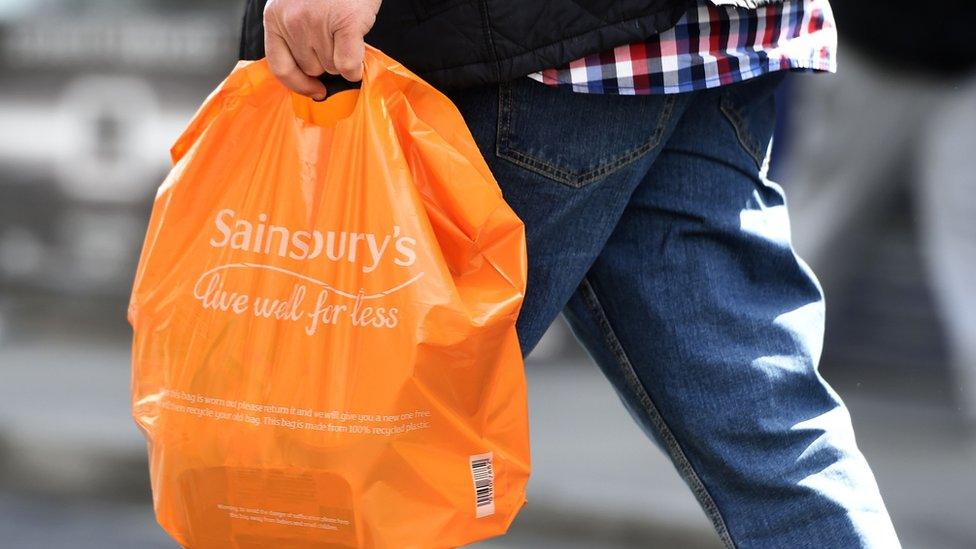 Man holding Sainsbury's bag