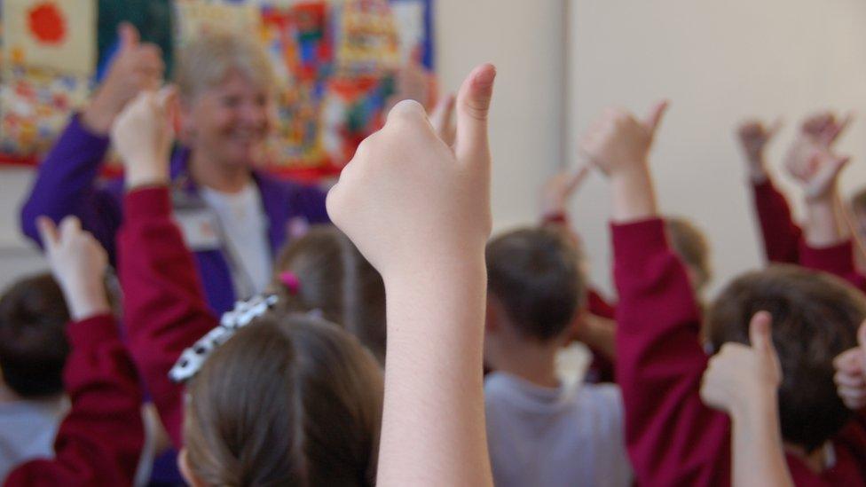 Pupil making thumbs up sign