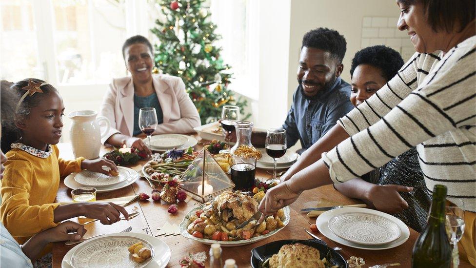 A family eats Christmas dinner.