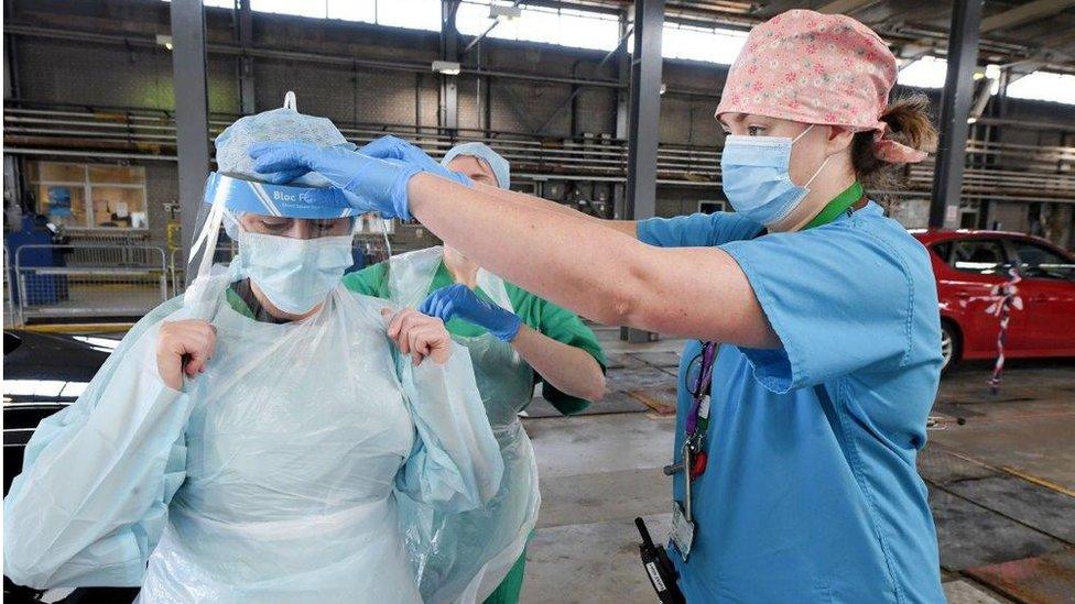 Health workers putting on PPE