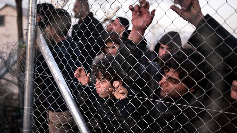 Refugees look through fence towards Macedonian side at the Greek border near village of Idomeni. 1 March 2016