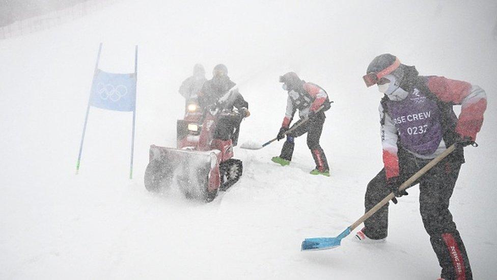 Crew members remove natural snow on a snowy day