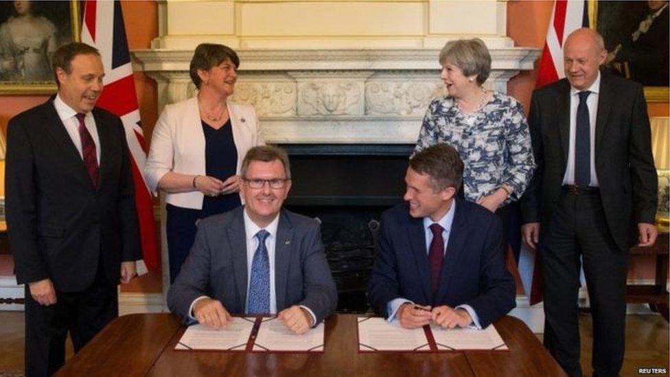 dup and tory politicians sign deal and smile