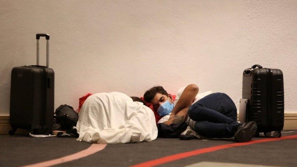 Tourists rests on the floor of the Cancun Convention Center, turned into an evacuation center, ahead of the arrival of Delta hurricane, in the touristic city of Cancun, Quintana Roo state, Mexico, late 06 October 2020