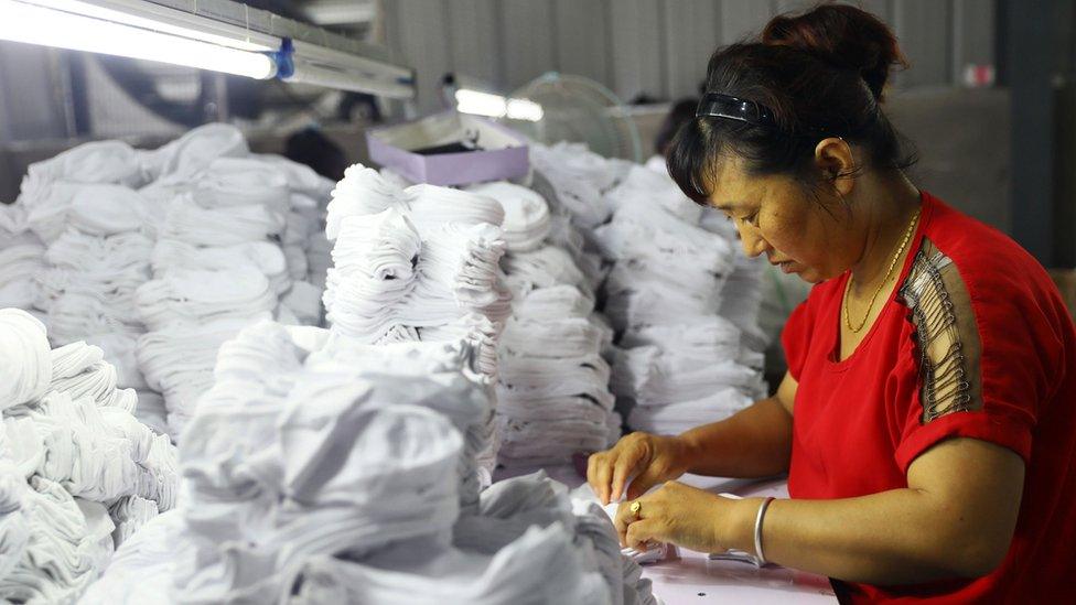 A woman works on socks that will be exported to the US at a factory in Huaibei in China's eastern Anhui province on August 7, 2018