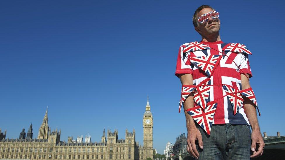 A man is tangled in bunting in front of Parliament