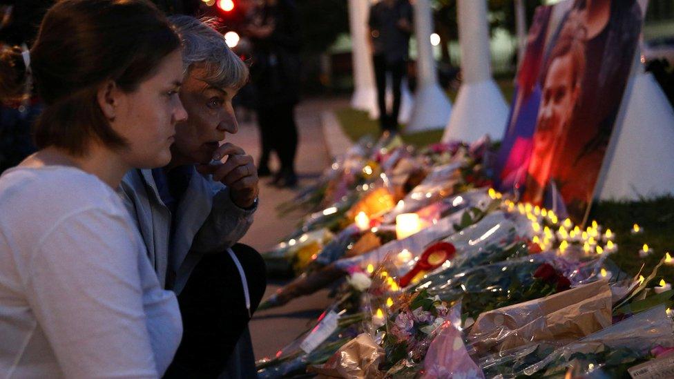 Two women looking at flowers in Parliament Square, London