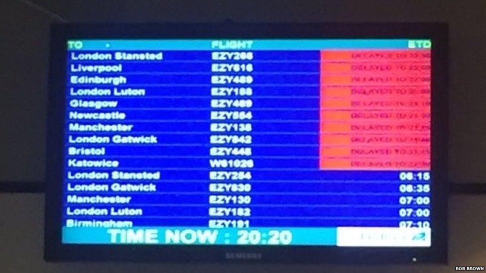 A departures board at Belfast International Airport showing delays to a number of flights