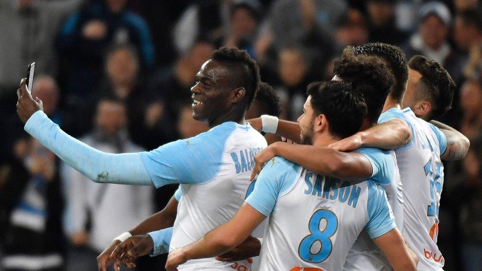 Balotelli and Marseille teammates taking a selfie on the pitch.