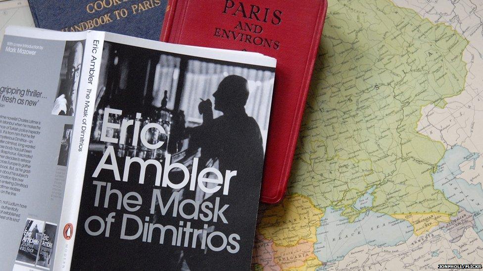 Copy of The Mask of Dimitrios sitting on vintage guide book to Paris and European map